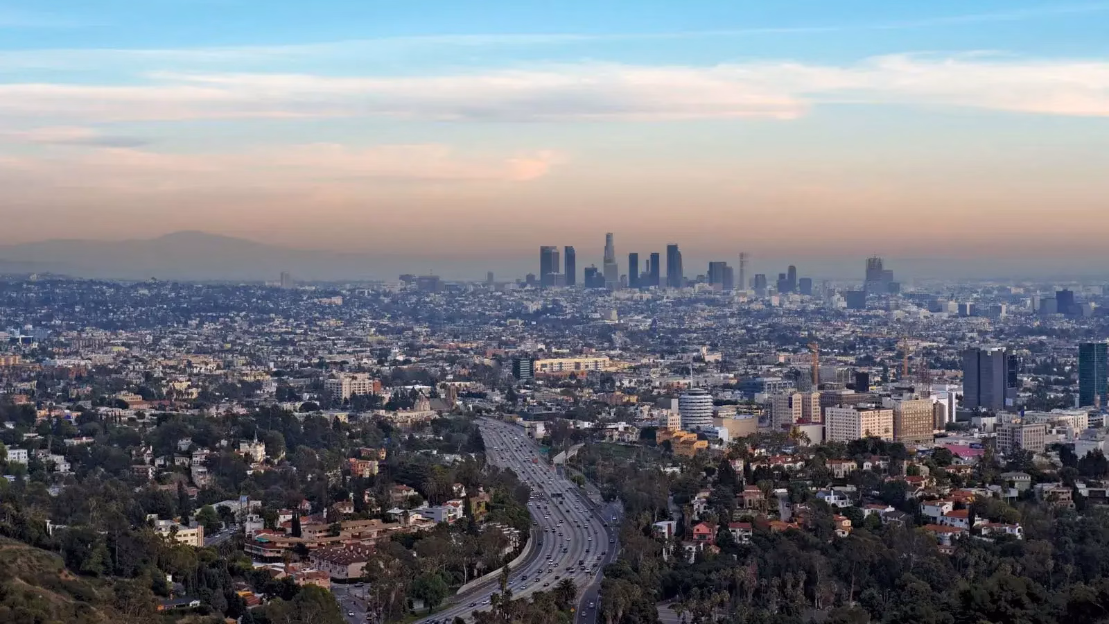 View of downtown Los Angeles from Hollywood Hills, with traffic on the US 101 in the foreground.